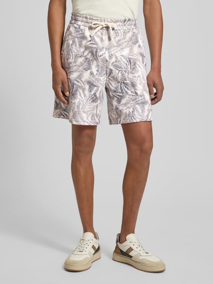 Männermodel trägt Shorts im Allover-Look von ARMANI EXCHANGE, beige-graues Muster, reine Baumwolle, Regular Fit, elastischer Bund, Ganzkörperansicht von vorne.