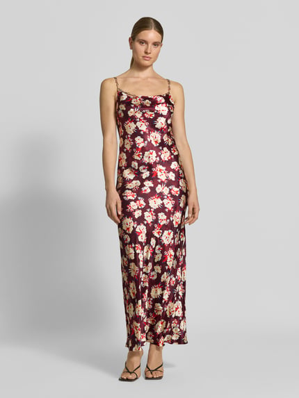 Frauenmodel trägt Maxikleid aus reiner Seide von Rabanne, figurbetontes, ärmelloses Design, geblümtes Muster in Rot und Creme, Spaghettiträger aus Gliederketten, Glanzoptik, Maxilänge; Ganzkörperansicht von vorne.