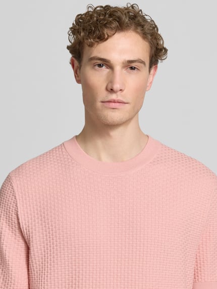 Männermodel trägt Regular Fit Strickshirt aus reiner Baumwolle Modell 'H-NILTON' von BOSS in Optik: Unifarben, Struktur-Nahaufnahme Oberkörper.