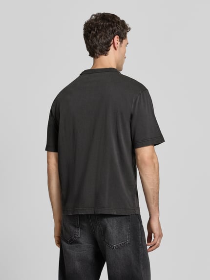 Męski model nosi T-Shirt z label-print, model 'AÉRO' od RETERNITY, czarna bawełna, krój regular fit, widok całej sylwetki z tyłu, długość tyłu w rozmiarze M: 67 cm.