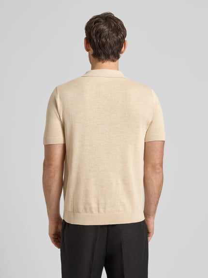 Männermodel trägt Regular Fit Poloshirt aus Baumwoll-Leinen-Mix Modell 'MATTIS' von SELECTED HOMME in Beige, kurzarm, Ganzkörperansicht Rückansicht.