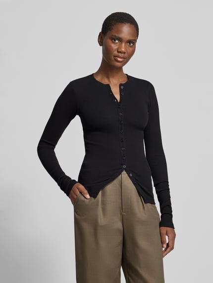Frauenmodel trägt Langarmshirt mit durchgehender Knopfleiste von black palms, unifarben, Rundhalsausschnitt, Knopfleiste vorne, Ganzkörperansicht von vorne.