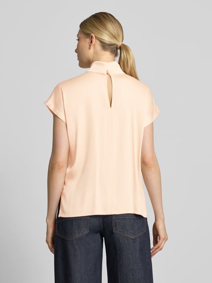 Frauenmodel trägt Blusenshirt mit Stehkragen Modell 'ALARIA' von DRYKORN in zartem Apricot, Regular Fit, Material-Mix, Rückenansicht, Ganzkörperansicht Rückansicht.