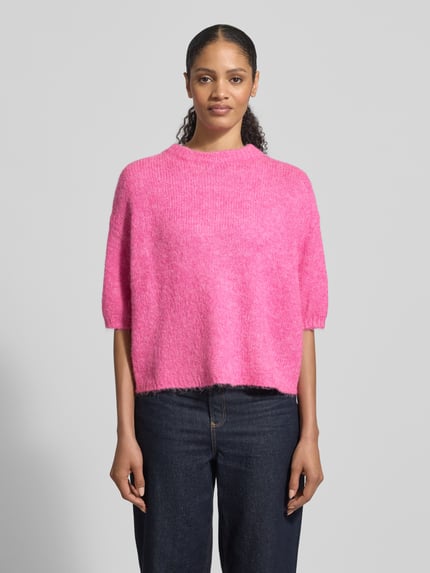 Vrouwenmodel draagt Relaxed Fit Pullover met lanawol-mix Model 'Otia' van B.Young in felle roze tricotlook, halflange mouwen, ronde hals, elastische mouwboorden, materiaalmix, ruglengte maat S 50 cm, mouwlengte 25 cm, geheel van voren.