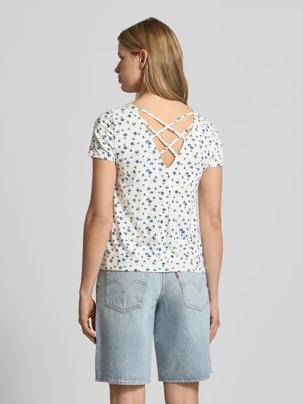 Frauenmodel trägt Regular Fit T-Shirt aus Viskose-Mix Modell 'BERA' von Only mit Allover-Muster, Schnüroptik hinten, Crêpe-Textur, Ganzkörperansicht Rückansicht.