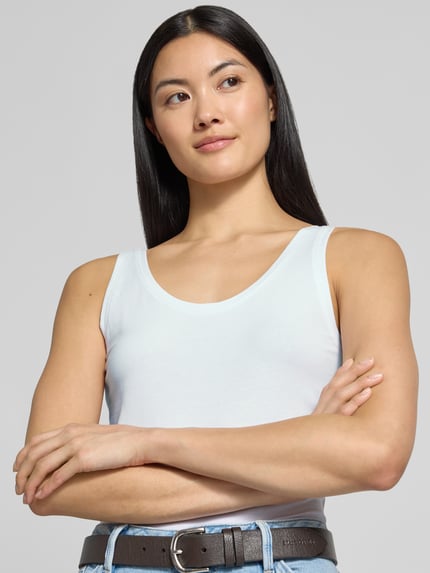 Frauenmodel trägt Slim Fit Tanktop aus Baumwoll-mix von s.Oliver RED LABEL in Weiß, glatte Textur, Nahaufnahme Oberkörper.