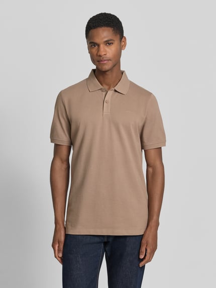 Męski model nosi Regular Fit Poloshirt aus reiner Baumwolle von s.Oliver RED LABEL, efekt: jednolity kolor, krój regular fit, wyhaftowane logo, kołnierzyk polo, dekolt w serek, listwa guzikowa, krótki rękaw, zakończenie rękawów: prążkowane, wykończenie: z rozcięciami po bokach, wykończenie materiału: pika, bawełna. Ganzkörperansicht z przodu.