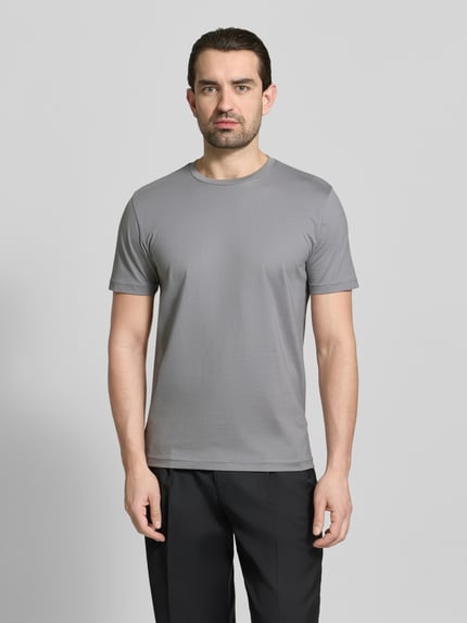Männermodel trägt T-Shirt mit Rundhalsausschnitt von Christian Berg Men, reine Baumwolle, Regular Fit, grau, glatte Textur, Ganzkörperansicht von vorne.