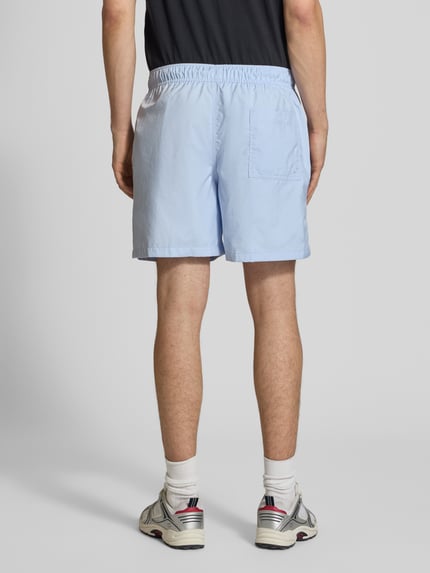 Männermodel trägt hellblaue Shorts mit Label-Stitching und elastischem Bund von Nike, Regular-Fit, Tunnelzug, Rückansicht Ganzkörperansicht.