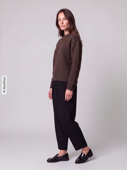 Frauenmodel trägt Regular Fit Pullover mit Woll-Anteil Modell 'ALLY' von PIECES in Braun zu schwarzer Hose, Ganzkörperansicht von vorne, KI-modifiziertes Bild.