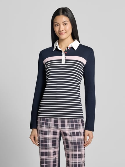 Modelka nosi Slim Fit Poloshirt aus Baumwoll-Mix von Marc Cain, mieszanka bawełny, kołnierzyk polo, z długim rękawem, długość tyłu w rozmiarze 36: 56 cm, wielokolorowy wzór w paski i kratkę, widok całej sylwetki z przodu.