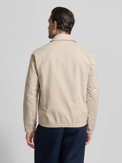 Męski model nosi Regular Fit Jacke mit Umlegekragen od MCNEAL, beżowa, materiał z bawełną, elastyczne wykończenia, widok całej sylwetki od tyłu