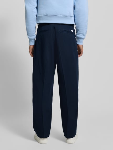 Männermodel trägt Weite Fit Hose aus reiner Baumwolle Modell 'MURRAY' von Tommy Hilfiger, unifarben, Ganzkörperansicht Rückansicht.