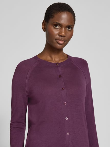 Frauenmodel trägt Strickjacke aus Wolle mit Raglanärmeln von BOSS in Unifarben, Feinstrick, durchgehende Knopfleiste, Nahaufnahme Oberkörper.