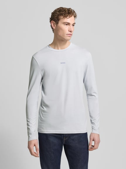 Męski model nosi Regular Fit bluzka z długim rękawem z mieszanki bawełny Model 'TCHARK' od BOSS, efekt: jednolity kolor, nadruk z logo, okrągły dekolt, długi rękaw, mieszanka bawełny, Ganzkörperansicht von vorne.