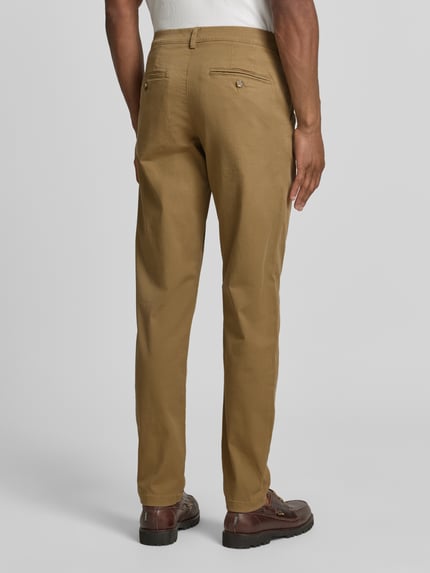 Männermodel trägt Slim Fit Chino aus Baumwoll-Mix Modell 'MILES' von Selected Homme in Unifarben mit Gesäßtaschen, Ganzkörperansicht Rückansicht.