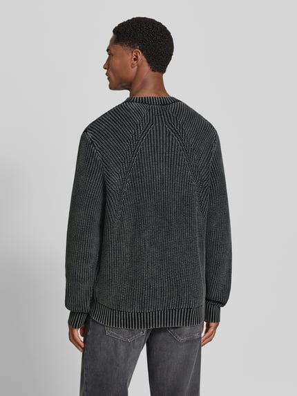 Męski model nosi sweter z dzianiny z prążkowanymi wykończeniami Strickpullover mit gerippten Abschlüssen von Antony Morato, bawełna, krój regular fit, Długość tyłu w rozmiarze M: 70 cm, Długość rękawów w rozmiarze M: 69 cm, widok całej sylwetki z tyłu.