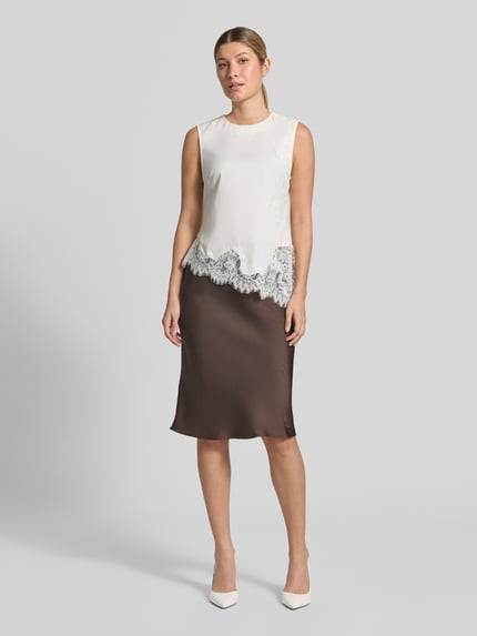 Frauenmodel trägt Satinrock mit elastischem Bund Modell 'Mindie' von Neo Noir, braun, Material-Mix mit Stretch, Straight Fit, Midirock, Ganzkörperansicht von vorne.