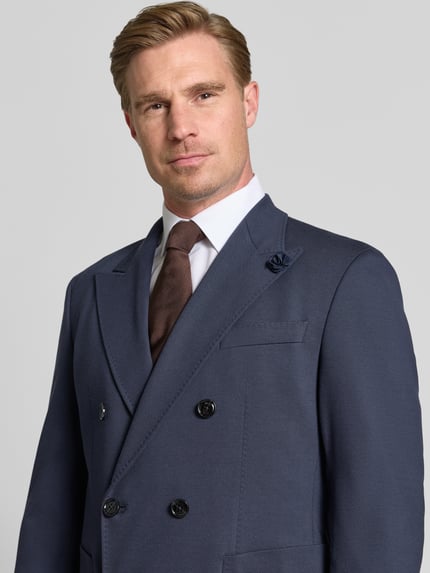 Männermodel trägt Regular Fit Anzughose mit Viskose-Anteil von JOOP!, glatter Stoff, klassisches Dunkelblau, Nahaufnahme Oberkörper. Herren Anzughose, elastischer Material-Mix, Zweiknopfleiste, aufgesetzte Taschen.