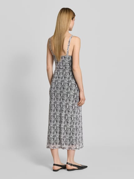 Frauenmodel trägt Körpernahes Freizeitkleid mit Allover-Muster Modell 'STEPH' von Vero Moda, Optik:Allover-Muster, Passform:Körpernah, Ausschnitt:V-Ausschnitt, Trägerform:schmale Träger, Saum:gerade, Grau-Schwarz-Töne, Ganzkörperansicht Rückansicht.
