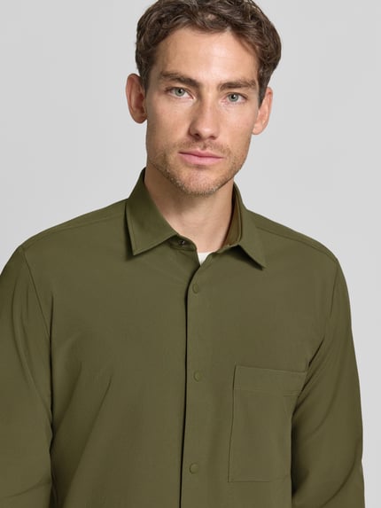 Männermodel trägt olivgrünes Relaxed Fit Freizeithemd mit Label-Patch Modell 'P-LEO-K-P-263' von BOSS, Nahaufnahme Oberkörper, Herren Hemdjacke.