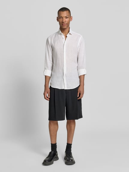 Männermodel trägt Regular Fit Chinoshorts mit Schurwoll-Anteil Modell 'FERY262F1X' von HUGO, Optik: Unifarben, Material-Mix Piqué, Ganzkörperansicht von vorne.