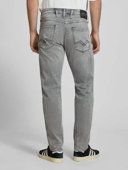 Męski model nosi Slim Fit Jeans im Used-Look Modell 'Anbass' od Replay, elastyczna bawełna, krój slim fit, szary, 5 kieszeni, szerokość w rozmiarze 32/32: 45 cm, długość nogawki od wewnątrz: 82 cm, zdjęcie całej sylwetki z tyłu.