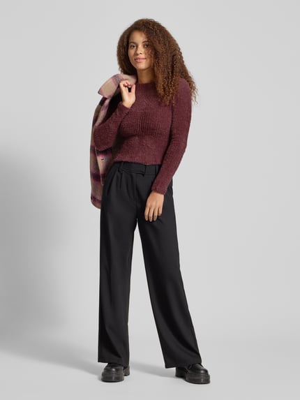 Frauenmodel trägt Slim Fit Strickpullover Modell 'VIOLA' von Only, unifarben, Label Stitching, Rundhals, langarm, Strick. Ganzkörperansicht von vorne.