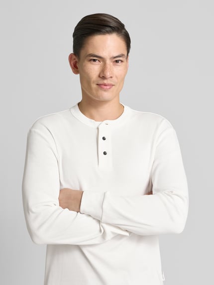 Männermodel trägt weißes Sweatshirt mit gerippten Abschlüssen von ARMANI EXCHANGE, reine Baumwolle, Regular Fit, Nahaufnahme Oberkörper.