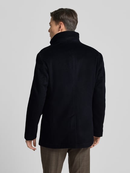 Männermodel trägt schwarze Wolljacke mit Stehkragen und Pattentaschen Modell 'Gary' von JOOP! Collection, Woll-Mix, Gerader-Schnitt, Rückenlänge 81 cm, Schulterbreite 48 cm, Brustweite 38 cm, Ärmellänge 67 cm, Ganzkörperansicht Rückansicht.