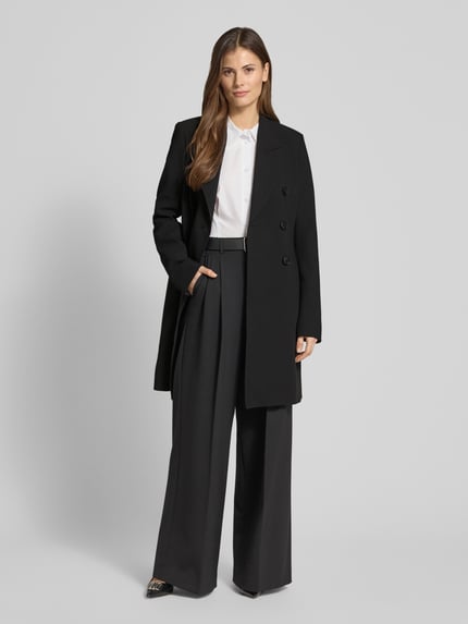 Vrouwenmodel draagt Regular Fit lange jas met viscose van Fuchs Schmitt, zwarte kleur, elastische materiaalmix, reverskraag, dubbele knoopsluiting, getailleerde pasvorm, maat 36, ruglengte 94 cm, schouderbreedte 44 cm, borstwijdte 48 cm, mouwlengte 68 cm, frontale full-body opname.