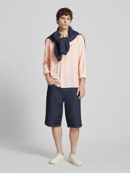 Männermodel trägt Relaxed Fit Freizeithemd aus Baumwoll-Modal-Mix von Tommy Jeans mit Optik:Allover-Muster, Ganzkörperansicht von vorne.
