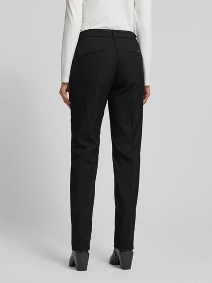 Frauenmodel trägt schwarze Straight Fit Stoffhose mit Viskose-Anteil Modell 'Maron' von Brax, Bügelfalten, Ganzkörperansicht Rückansicht.