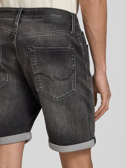 Mannenmodel draagt Regular Fit Jeansshorts met omslag model 'RICK' van Jack & Jones in katoenmix met stretch, used-look, detailopname rug.