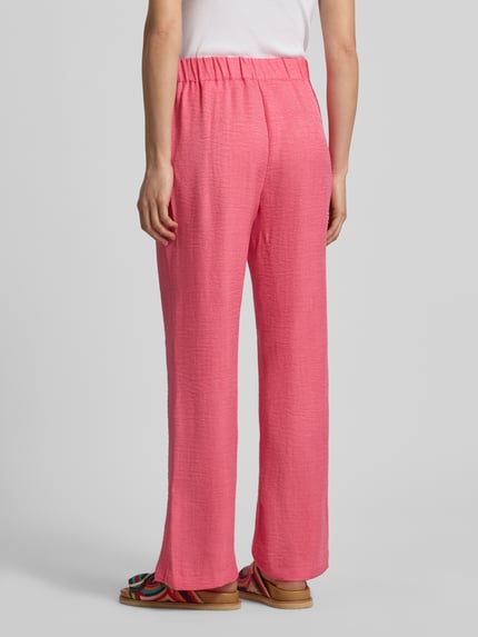Frauenmodel trägt Hose in Denim-Optik Modell 'CHARISSA' von Soyaconcept, pink, elastischer Bund, strukturierte Oberfläche, Ganzkörperansicht Rückansicht. Damen Hose, Wide Leg, Bundweite 36 cm, Innenbeinlänge 75 cm, Größe S.