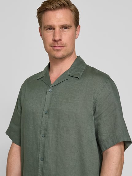 Męski model nosi Relaxed Fit Leinenhemd mit Resortkragen Modell 'KYLIAN' od SELECTED HOMME, kolor jednolity, krój relaxed fit, czysty len, krótki rękaw, z przodu, zbliżenie górnej części ciała