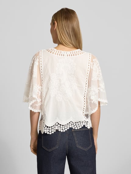 Vrouwenmodel draagt Blusenshirt aus Spitze van Apricot in wit met kant, recht model, vleermuismouwen, puur katoen, ruglengte maat S 46 cm, mouwlengte 34 cm, rugaanzicht, detailopname.