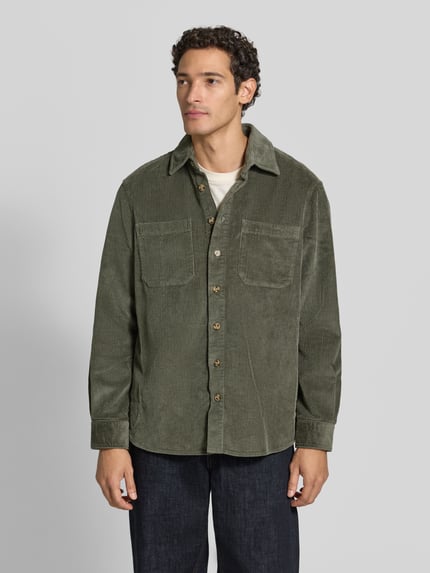 Männermodel trägt Regular Fit Hemdjacke aus Cord mit Kentkragen von Christian Berg Men, olivegrün, Brusttaschen, Ganzkörperansicht von vorne.
