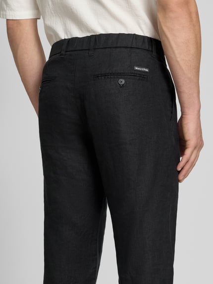 Männermodel trägt Tapered Leinenhose mit Gürtelschlaufen Modell 'OSBY JOGGER' von Marc O'Polo, Optik: Unifarben, Material: Leinen, Ganzkörperansicht Rückansicht.