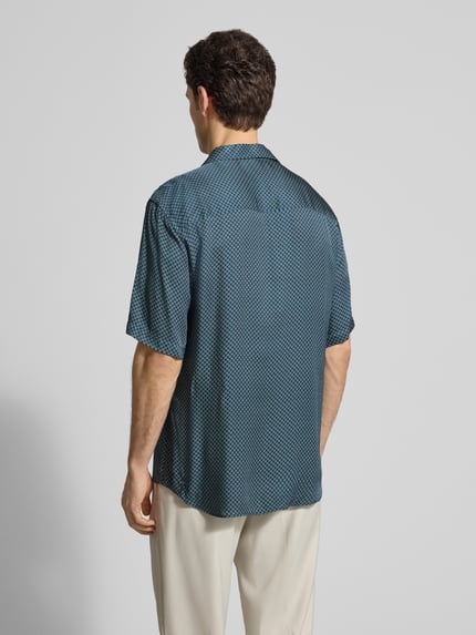 Mannenmodel draagt Regular Fit Freizeithemd aus Viskose van CRUNA in blauwe kleur, korte mouwen en reverskraag, geheel van achteren.