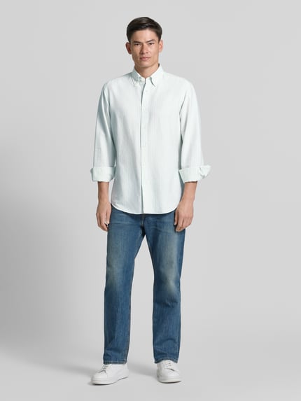Männermodel trägt Regular Fit Freizeithemd aus Lyocell-Baumwoll-Mix Modell 'RICOPLUS' von BOSS Orange, gestreift, weiß-blau, Ganzkörperansicht von vorne.