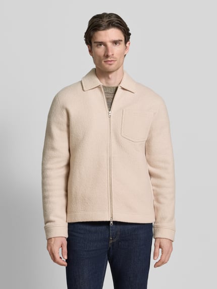 Męski model nosi Regular Fit Hemdjacke aus reiner Wolle Modell 'HANNES' od Samsøe Samsøe, kremowy kolor, widok całej sylwetki z przodu. Kent kołnierz, zamek błyskawiczny, kieszeń na piersi, długość tyłu dla rozmiaru M: 68 cm.