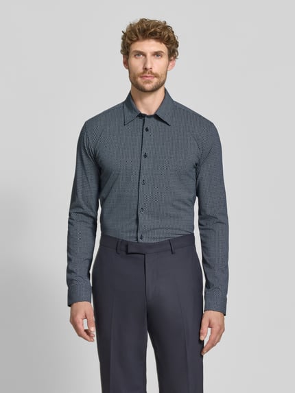 Männermodel trägt Slim Fit Businesshemd aus Baumwoll-Mix Modell 'P-ROAN-K-F-263' von BOSS in Dunkelblau mit feinem Muster, Ganzkörperansicht von vorne. Herren Businesshemd von BOSS