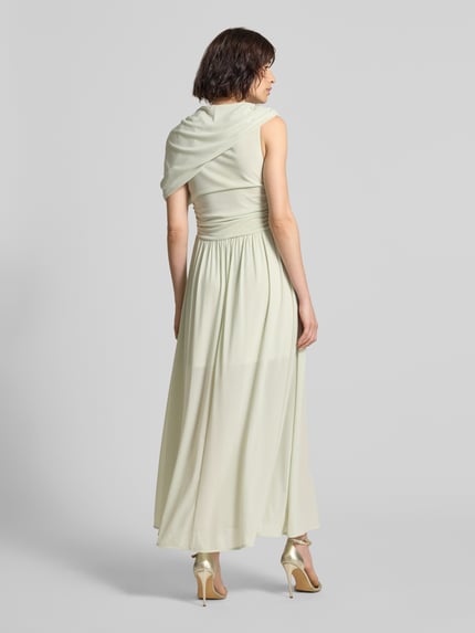 Frauenmodel trägt Maxikleid mit Drapierungen Modell 'MEJSE' von Copenhagen Muse in hellem Grün, Material-Mix mit Stretch-Anteil, taillierter Schnitt, Rückenlänge bei Größe S 134 cm, Brustweite 37 cm, Ganzkörperansicht Rückansicht.