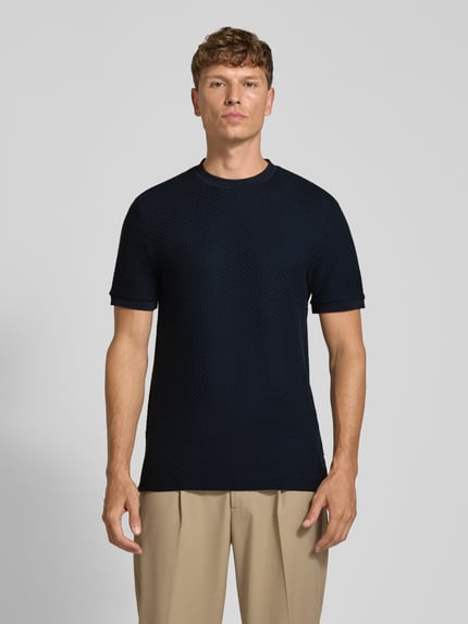 Männermodel trägt T-Shirt mit strukturierter Oberfläche Modell 'H-thompson 82' von BOSS, unifarben dunkelblau, Jersey, Rundhals, Ganzkörperansicht von vorne.