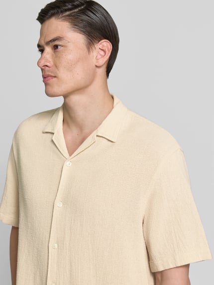 Männermodel trägt Relaxed Fit Freizeithemd aus reiner Baumwolle Modell 'RLXCAL' von SELECTED HOMME, Optik: Unifarben, Nahaufnahme Oberkörper.