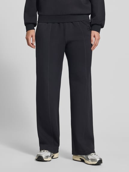 Mannelijk model draagt Wide Fit broek uit viscosemix met elastische band en steekzakken van Liu Jo, zwart, detailopname benen.
