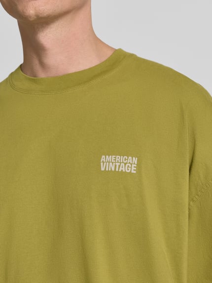 Männermodel trägt T-Shirt mit Logo-Print Modell 'GIXY' von American Vintage, olivgrün, reine Baumwolle, Nahaufnahme Oberkörper.