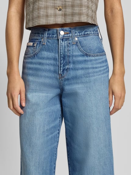 Frauenmodel trägt Wide Fit Jeans mit Label-Detail von Calvin Klein Jeans, Used-Look, Reine Baumwolle, Nahaufnahme Oberkörper.