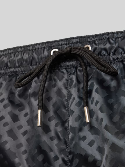 Produktfoto, Regular Fit Badeshorts mit Tunnelzug Modell 'JACQUES' von BOSS in Schwarz, unifarbene Satin-Struktur, Logo-Muster, Detailaufnahme